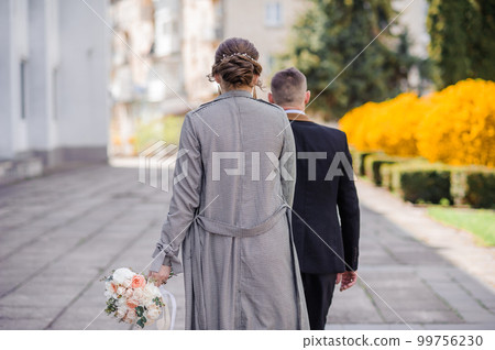 The boy and the girl walk holding hands. Man holding woman's hand The boy and the girl walk holding hands. Man holding woman's hand 99756230
