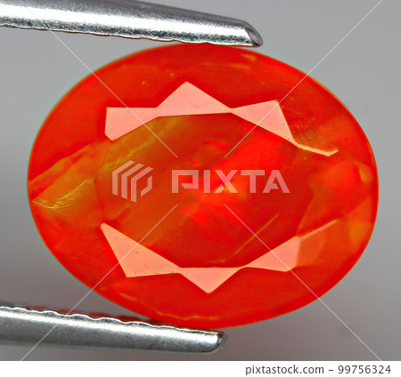 Natural gemstone fire opal on gray background 99756324