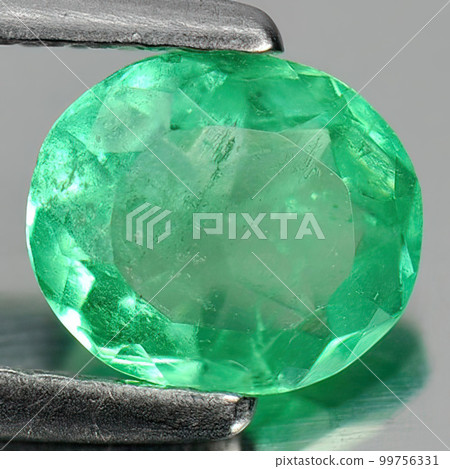 Natural gemstone green emerald on gray background Natural gemstone green emerald on gray background 99756331