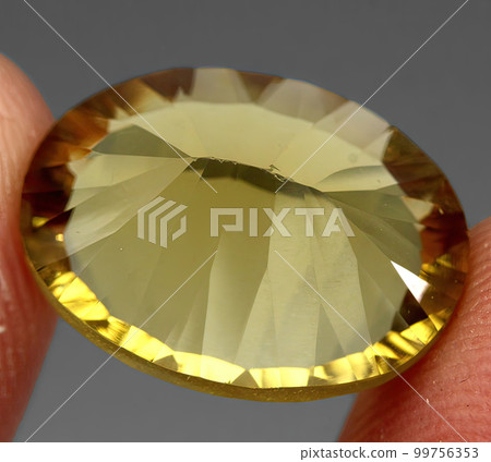 Natural gemstone yellow citrine on gray background 99756353