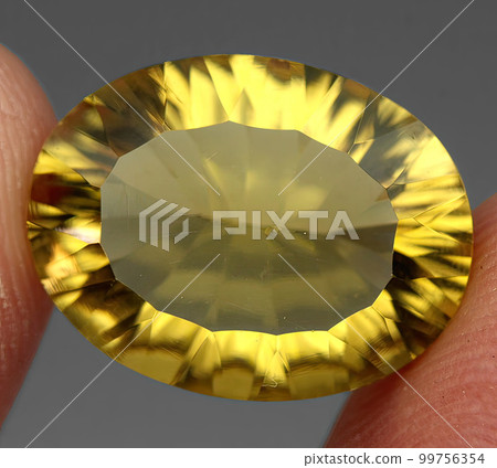 Natural gemstone yellow citrine on gray background 99756354