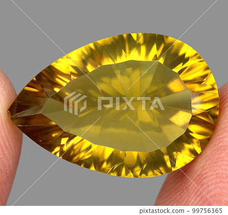 Natural gemstone yellow citrine on gray background 99756365