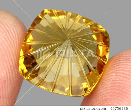 Natural gemstone yellow citrine on gray background 99756386