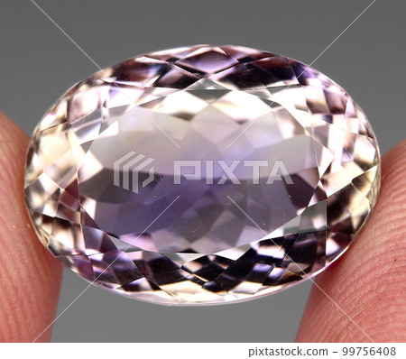 Natural gemstone bicolor ametrine on a gray background 99756408