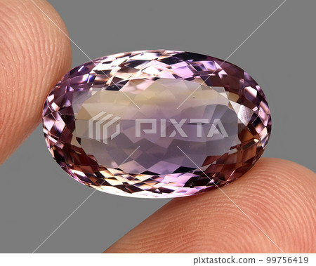 Natural gemstone bicolor ametrine on a gray background 99756419