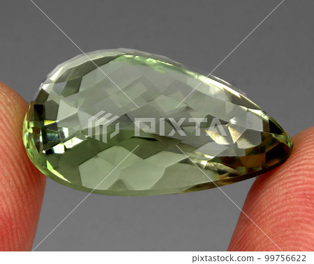 Natural precious green amethyst prasiolite on a gray background Natural precious green amethyst prasiolite on a gray background 99756622