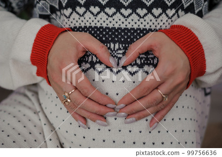 Beautiful pregnant woman holding her hands on her belly Beautiful pregnant woman holding her hands on her belly 99756636