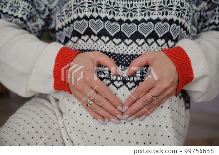 Beautiful pregnant woman holding her hands on her belly Beautiful pregnant woman holding her hands on her belly 99756638