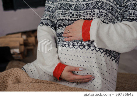 Beautiful pregnant woman holding her hands on her belly Beautiful pregnant woman holding her hands on her belly 99756642