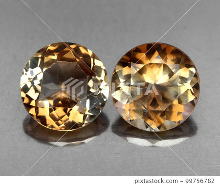 Beautiful natural gemstone imperial topaz on a gray background Beautiful natural gemstone imperial topaz on a gray background 99756782