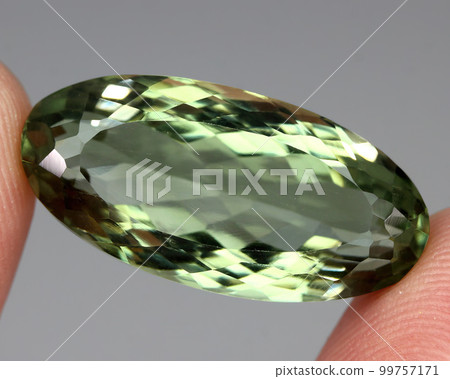 Natural stone green amethyst on a gray background Natural stone green amethyst on a gray background 99757171