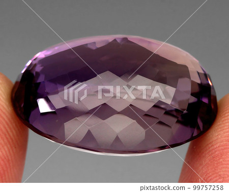 Natural gemstone purple amethyst on gray background 99757258