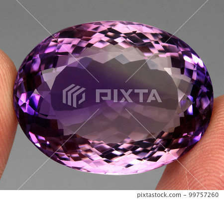 Natural gemstone purple amethyst on gray background 99757260
