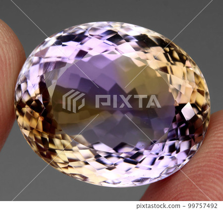 Natural gemstone bi color ametrine on gray background 99757492
