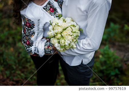 A bouquet of flowers in the hands of the bride. A bouquet of white flowers in the hands of a woman. Wedding A bouquet of flowers in the hands of the bride. A bouquet of white flowers in the hands of a woman. Wedding 99757619