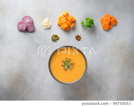 dark bowl with pumpkin soup with seeds, spices and food ingredients. dark bowl with pumpkin soup with seeds, spices and food ingredients. 99758053