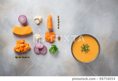autumn pumpkin soup in dark bowl and ingredients for cooking. autumn pumpkin soup in dark bowl and ingredients for cooking. 99758054