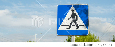 Vertical signage of crosswalk over cloudy sky, road sign pedestrian crossing. Attention road sign 99758484