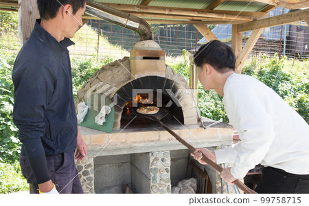 making pizza in a pizza oven 99758715