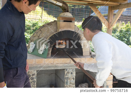 making pizza in a pizza oven 99758716
