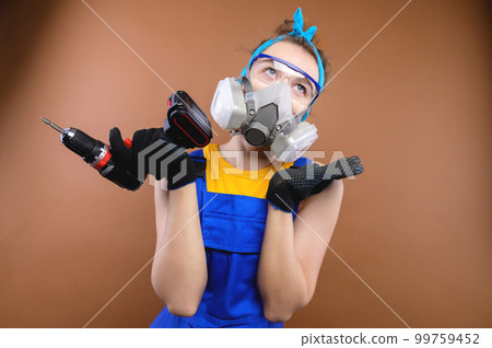 Young insecure worker, handyman, woman in a t-shirt, glasses, holding a drill on a plain background. Tools, accessories for the repair room. Home renovation concept Young insecure worker, handyman, woman in a t-shirt, glasses, holding a drill on a plain background. Tools, accessories for the repair room. Home renovation concept 99759452