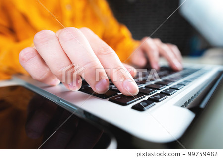 Close-up of female hands typing on a laptop keyboard indoors. Businesswoman working from home or student browsing information Close-up of female hands typing on a laptop keyboard indoors. Businesswoman working from home or student browsing information 99759482