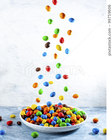 Multi-colored round candies in colored glaze in large quantities in a plate Multi-colored round candies in colored glaze in large quantities in a plate 99759606