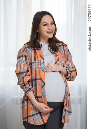 Pregnant woman demonstrates belly expecting child birth 99759653