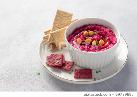 beetroot hummus in white bowl with chickpeas and crackers beetroot hummus in white bowl with chickpeas and crackers 99759693