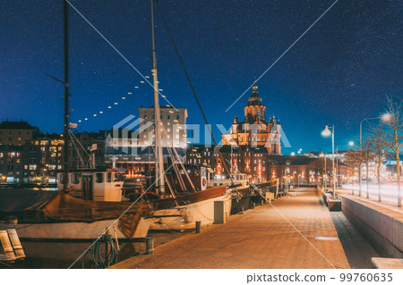 Helsinki, Finland. Pier With Boats, Pohjoisranta Street And View Of Uspenski Cathedral In Evening Night Illuminations. Colourful Night Starry Sky In Dark Blue Colors. Sky Glowing Stars Background Helsinki, Finland. Pier With Boats, Pohjoisranta Street And View Of Uspenski Cathedral In Evening Night Illuminations. Colourful Night Starry Sky In Dark Blue Colors. Sky Glowing Stars Background 99760635