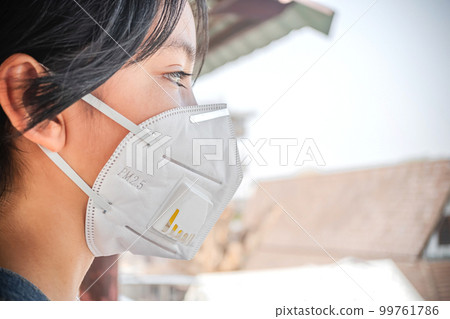 Coronavirus and Air pollution pm2.5 concept. Young girl wearing face mask protective for spreading of Coronavirus Disease 2019. Close up of young girl with N95 mask on face 99761786