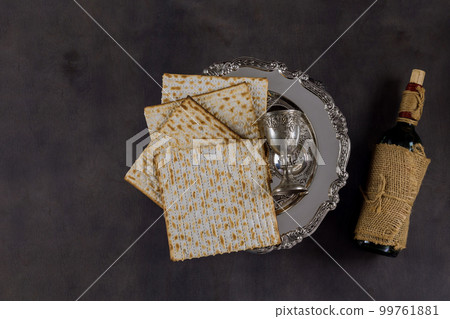 Jewish holiday Passover is kosher unleavened matzah bread and cup of kosher kiddush wine for Pesach Jewish holiday Passover is kosher unleavened matzah bread and cup of kosher kiddush wine for Pesach 99761881