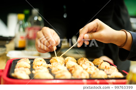 Working together at a takoyaki party Working together at a takoyaki party 99763399