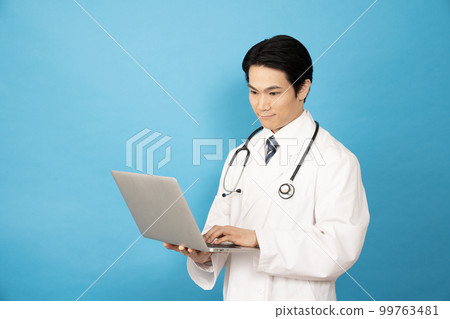 Male doctor with laptop on blue background 99763481