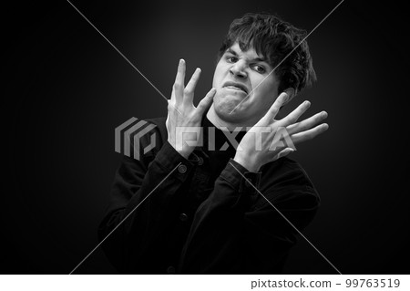 crazy young man with awesome hairdo grimacing 99763519