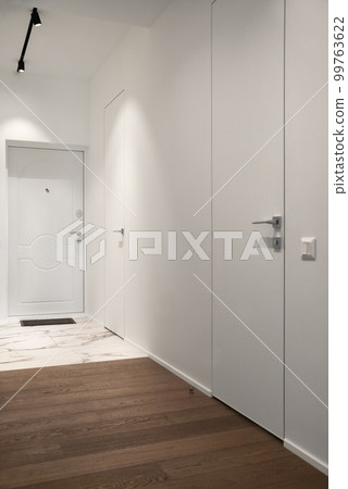 Bright hallway with a wall made of mirror. Mirrored door 99763622