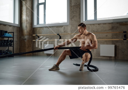 A strong man pulling training sports rope front view 99765476