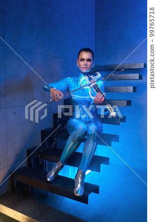 Futuristic concert of young woman violinist in neon light 99765718