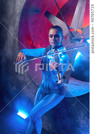 Young woman playing electronic violin in neon glowing light 99765719