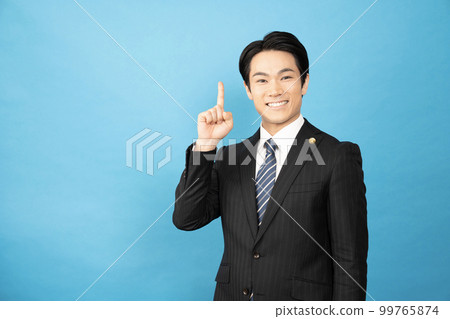 A lawyer smiling with his index finger up on a blue background 99765874
