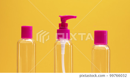 Closeup fuchsia travel bottle kit for liquids, cream. Toiletries Beauty Kit on yellow orange background. Airplane approved luggage reusable container size. Summer time, vacation concept Horizontal. Closeup fuchsia travel bottle kit for liquids, cream. Toiletries Beauty Kit on yellow orange background. Airplane approved luggage reusable container size. Summer time, vacation concept Horizontal. 99766032
