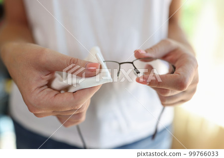 Woman wiping glasses with white cleaning napkin Woman wiping glasses with white cleaning napkin 99766033