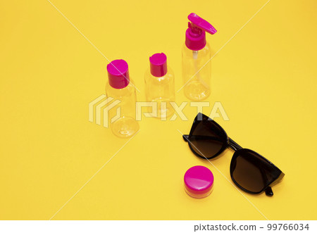 Airplane luggage fuchsia bottle container size with sun glasses on yellow orange background. Transparent travel toiletries beauty kit. Vacation summertime concept, , copy space. Horizontal plane. Airplane luggage fuchsia bottle container size with sun glasses on yellow orange background. Transparent travel toiletries beauty kit. Vacation summertime concept, , copy space. Horizontal plane. 99766034