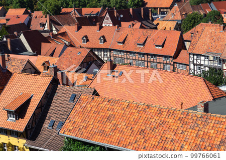 Scenic panoramic view traditional shingle tiled red rooftop old ancient medieval european german small town Quedlinburg. Unesco heritage list travel destination. Historical fachwerk house roofs 99766061