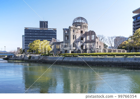 蔥鬱的綠植和原子彈爆炸圓頂屋。和平紀念公園的鬱鬱蔥蔥綠植。元安川和原子彈爆炸圓頂屋。廣島旅遊景點。 99766354
