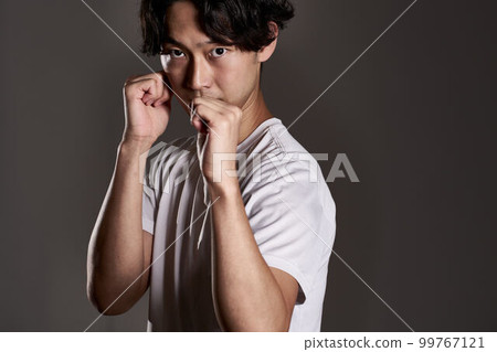A young man taking a fighting pose with sharp eyes 99767121
