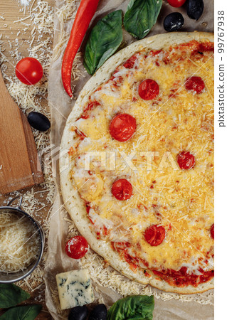 homemade italian four cheeses pizza. Pizza on rustic wooden background with tomato, cheese, basilic. Copy space. Flat lay picture for recipe or menu homemade italian four cheeses pizza. Pizza on rustic wooden background with tomato, cheese, basilic. Copy space. Flat lay picture for recipe or menu 99767938