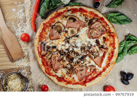 Pizza with chicken cheese and pepperoni, a piece of which is cut and laid out like a pakman, is on a wooden board and a brown background. Cheese spreads flowing streaks Pizza with chicken cheese and pepperoni, a piece of which is cut and laid out like a pakman, is on a wooden board and a brown background. Cheese spreads flowing streaks 99767939