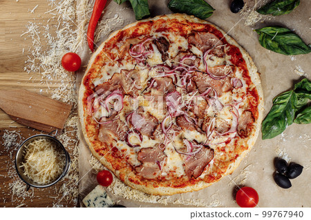 Pizza with chicken cheese and pepperoni, a piece of which is cut and laid out like a pakman, is on a wooden board and a brown background. Cheese spreads flowing streaks Pizza with chicken cheese and pepperoni, a piece of which is cut and laid out like a pakman, is on a wooden board and a brown background. Cheese spreads flowing streaks 99767940