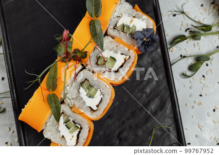 Rainbow Sushi Roll with salmon, eel, tuna, avocado, royal prawn, cream cheese Philadelphia, caviar tobica, chuka. Sushi menu. Japanese food.  99767952